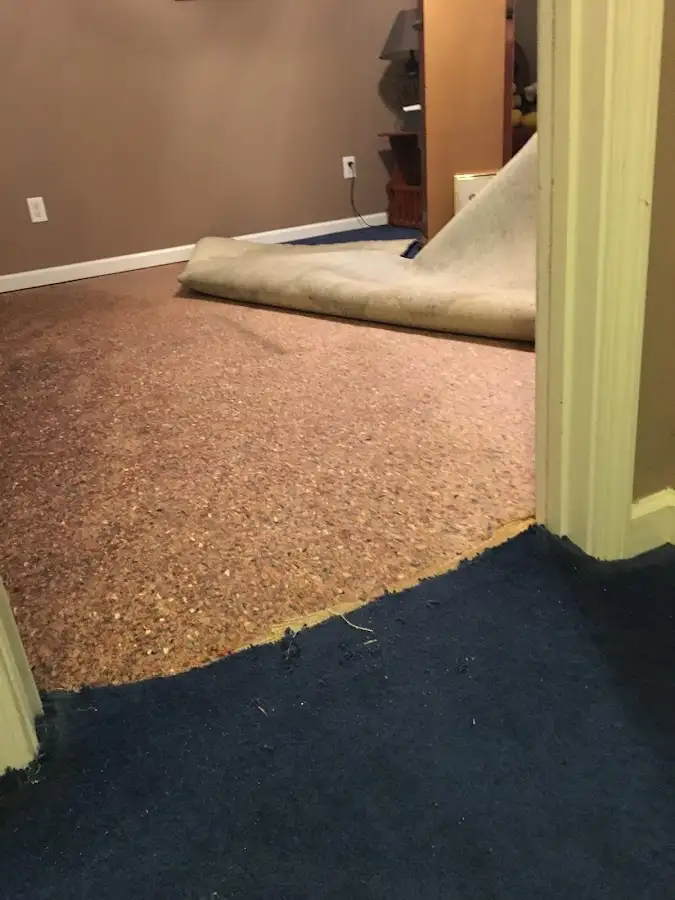 Carpet pad removal revealing water damage during Water Mitigation Services in Milledgeville